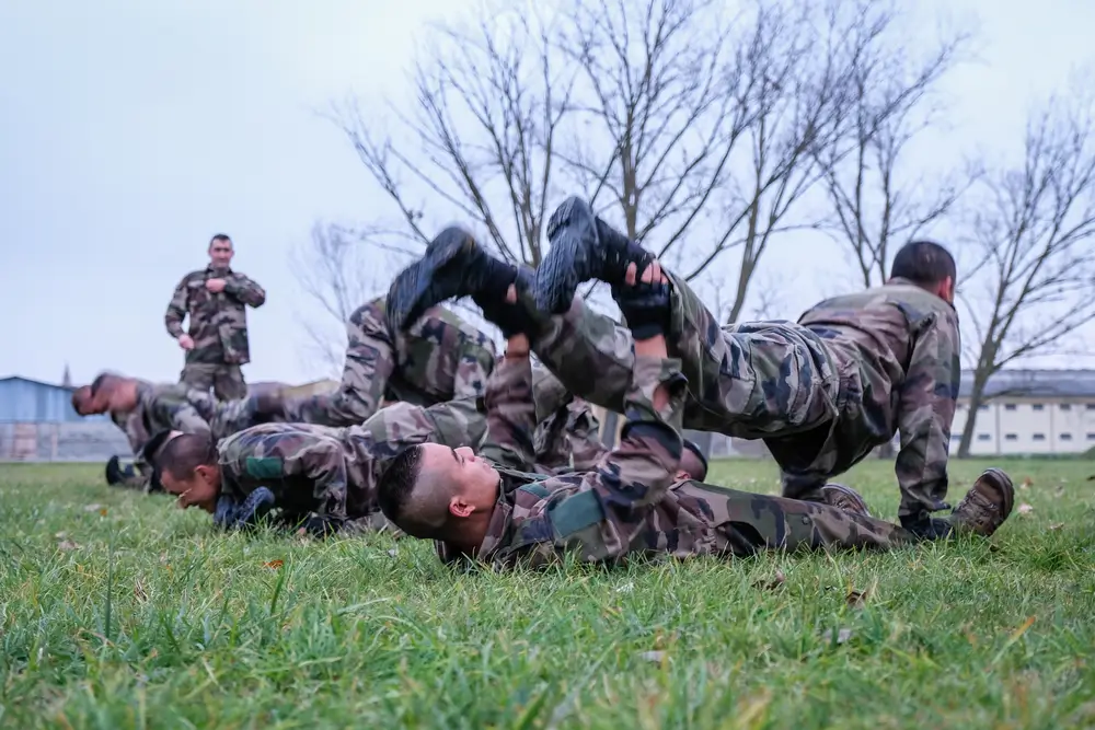 Légionnaires en formation lors d'un entraînement physique intense en terrain militaire