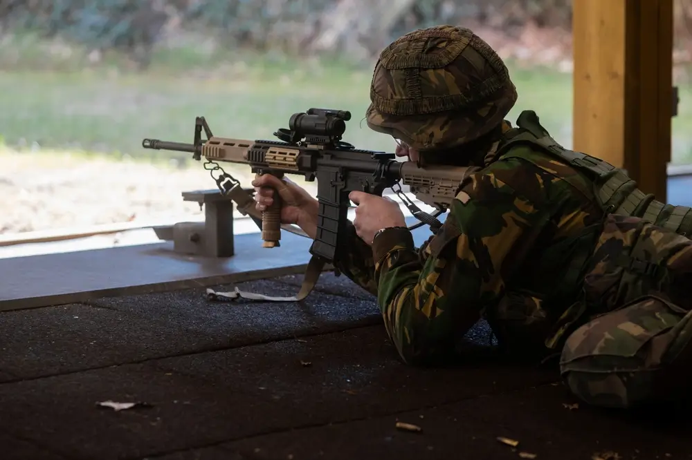 Légionnaire en position couchée effectuant un exercice de tir au fusil d'assaut lors de son entraînement militaire.