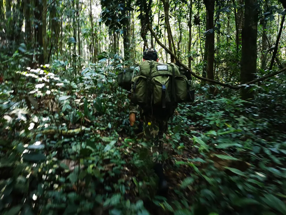 Légionnaire du 3e REI en patrouille avec un sac à dos imposant dans la jungle dense de Guyane.