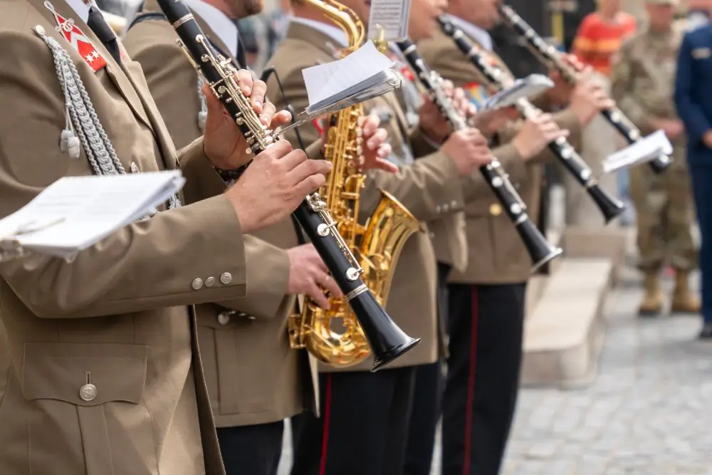 Musiciens d'une fanfare militaire en uniforme jouant de la clarinette et du saxophone lors d'une cérémonie officielle.