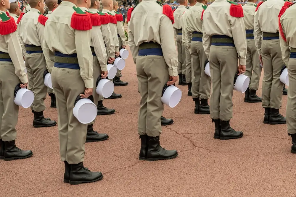 Légionnaires en tenue de parade, képi blanc à la main, lors d'une cérémonie officielle de la Légion étrangère.