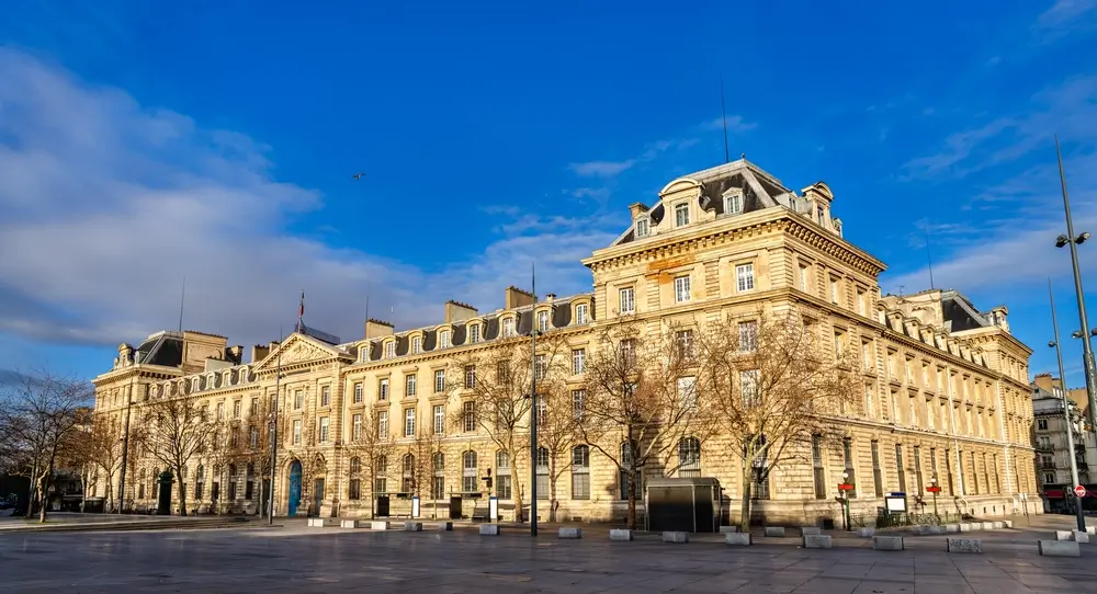 Façade en pierre d'une caserne militaire avec emblème sculpté, bâtiment historique de l'armée au style classique.