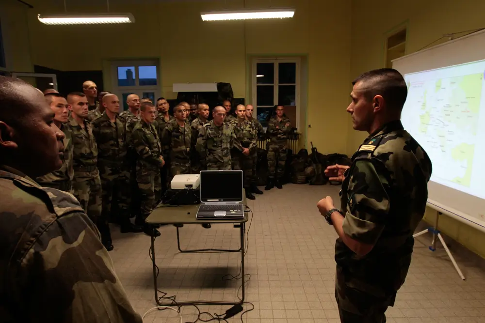 Militaires en uniforme assistant à une formation en atelier pour préparer leur reconversion professionnelle.